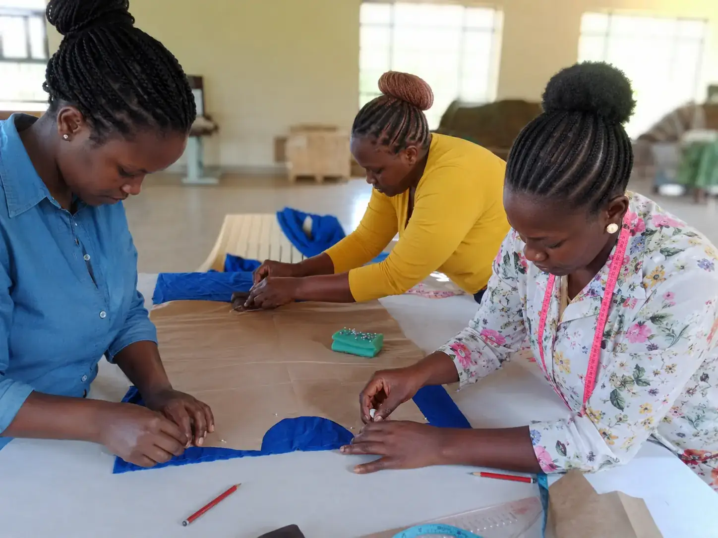 Privacy-safe image of Kenyan women participating in practical garment-skills training